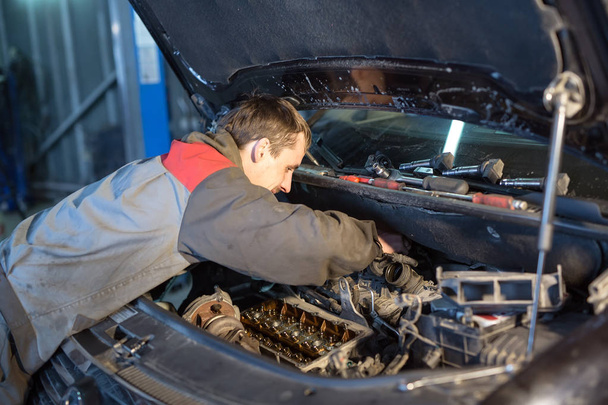 Auto mechanic working in garage. Repair service - Zdjęcie, obraz