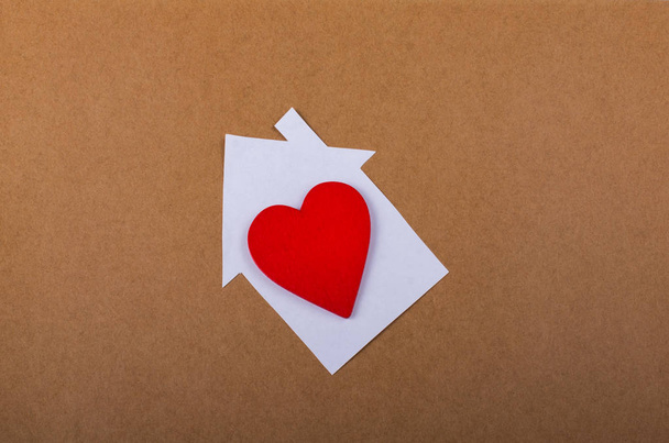 Piccola casa di carta e un cuore in mano
 - Foto, immagini