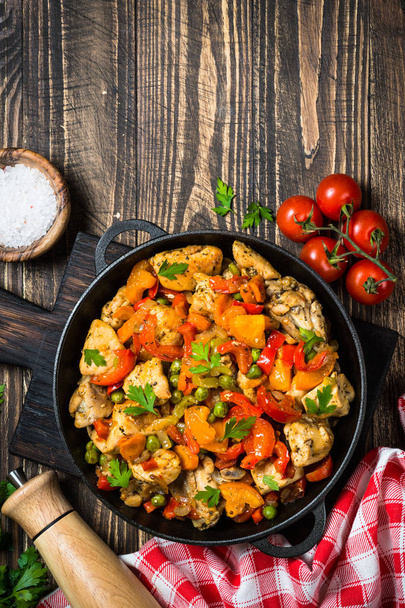 Chicken Stir fry with vegetables on wooden table. - Фото, зображення
