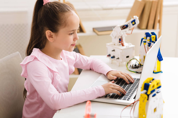 Creating robotics project. Girl typing plan of robot model - Photo, Image