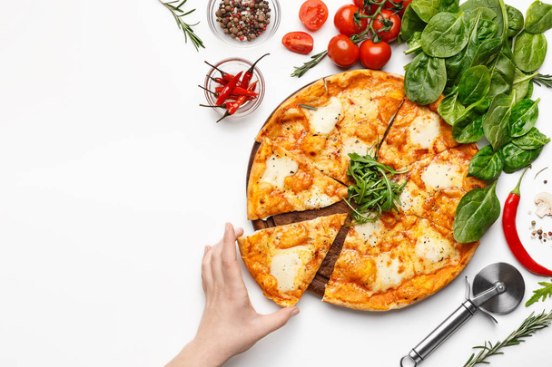 Ragazza che prende fetta di pizza al formaggio sul tavolo bianco
 - Foto, immagini