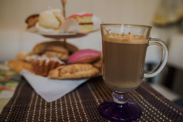 Fotografia de alimentos. Cappuccino quente com diferentes doces caseiros em uma cesta na mesa em café fast food. - Foto, Imagem