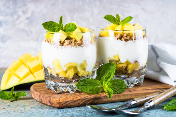 Parfait with yogurt, mango and granola. - Foto, Bild