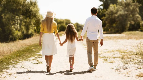 田舎を歩く両親と小さな女の子 - 写真・画像