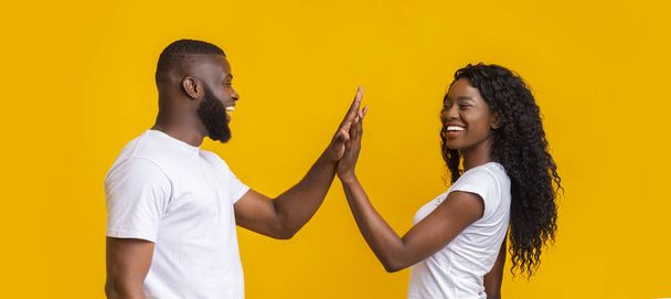 Cheerful man and woman giving each other high five - Photo, Image