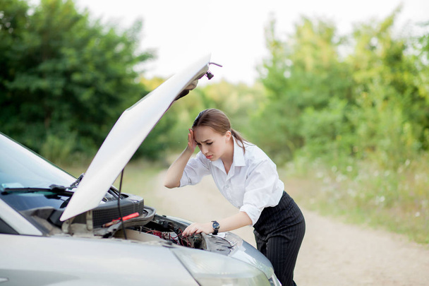 Young woman by the roadside after her car has broken down She op - 写真・画像