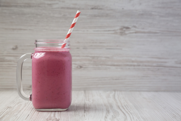 Raspberry smoothie in a glass jar on a white wooden background,  - Foto, Bild