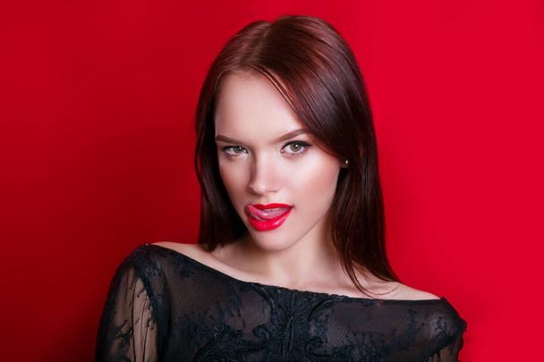 Emotional girl. Beautiful modern model with red lips shows tongue - Zdjęcie, obraz