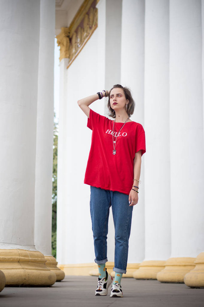 Une fille dans un T-shirt rouge se tient à la colonne
 - Photo, image