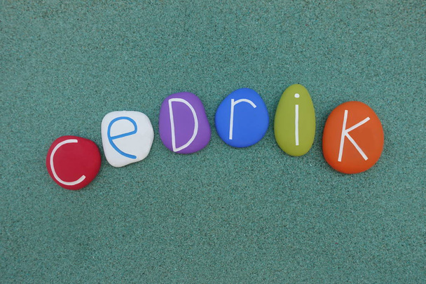 Cedrik, nome maschile composto da pietre colorate su sabbia verde
 - Foto, immagini