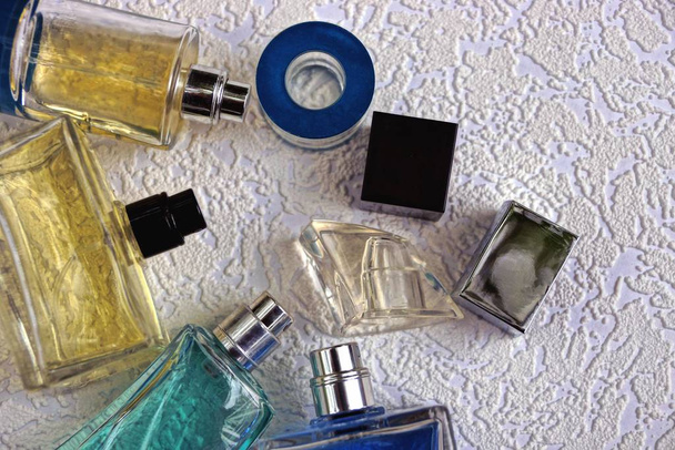 Маленькі скляні пляшки з парфумами на сірому фоні
 - Фото, зображення