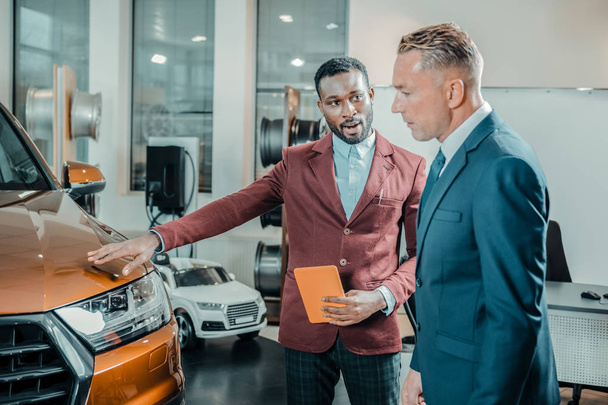Car dealer helping his client buying a car. - Φωτογραφία, εικόνα