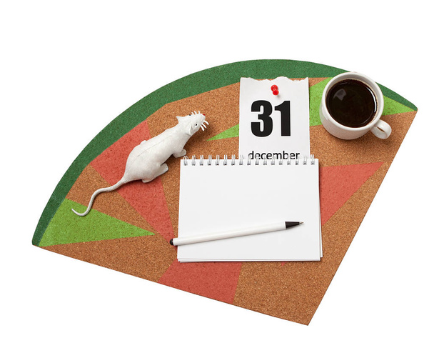 A white rat, a calendar sheet, coffee and a notebook with a pen on a cork Board. - Фото, изображение