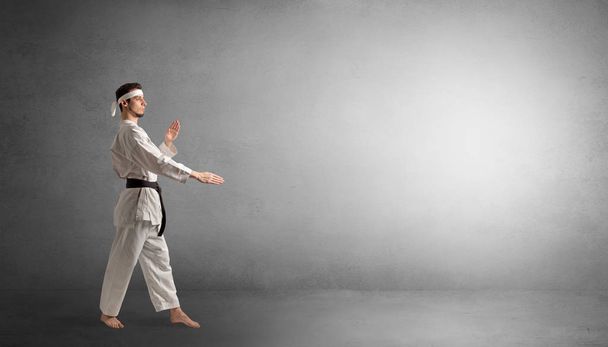 Small karate man fighting in an empty space - Фото, зображення