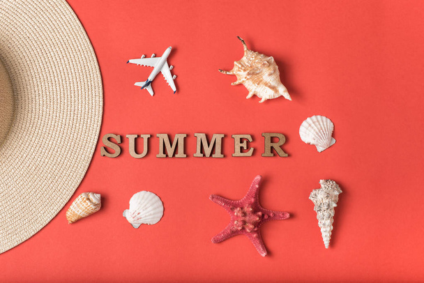 Wort Sommer aus Holzbuchstaben. Muscheln, kleines Flugzeug und ein Teil eines Hutes. lebende Korallen Hintergrund. flach lag. Meereskonzept - Foto, Bild