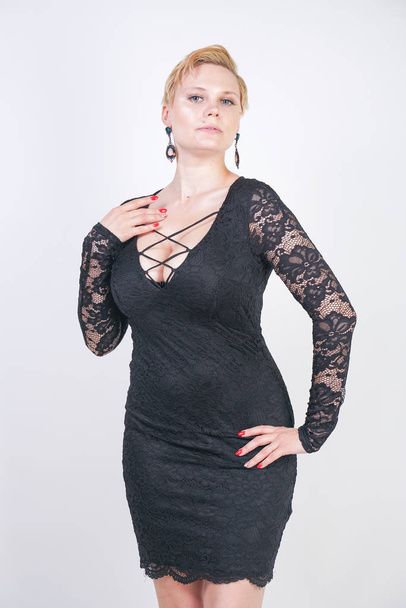 Portrait of attractive chubby young woman in tight black dress - Photo, image