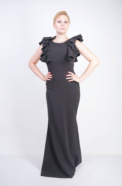 Portret van aantrekkelijke mollige jonge vrouw in strakke zwarte jurk - Foto, afbeelding