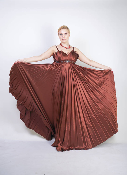 young pregnant girl in a long brown pleated evening dress - Foto, Imagem