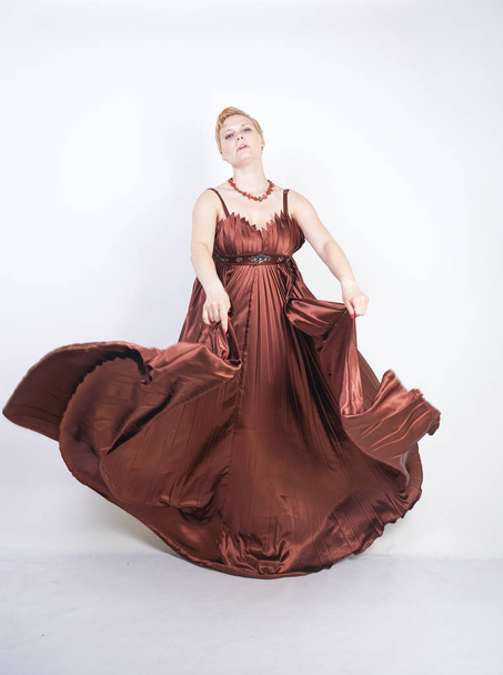 young pregnant girl in a long brown pleated evening dress - Foto, Imagen