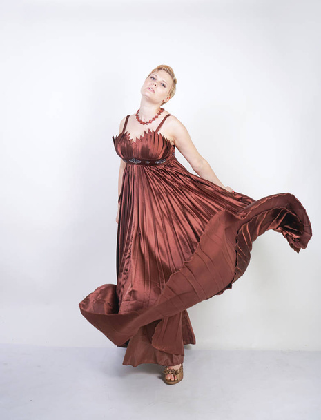 joven embarazada en un vestido de noche largo plisado marrón
 - Foto, Imagen