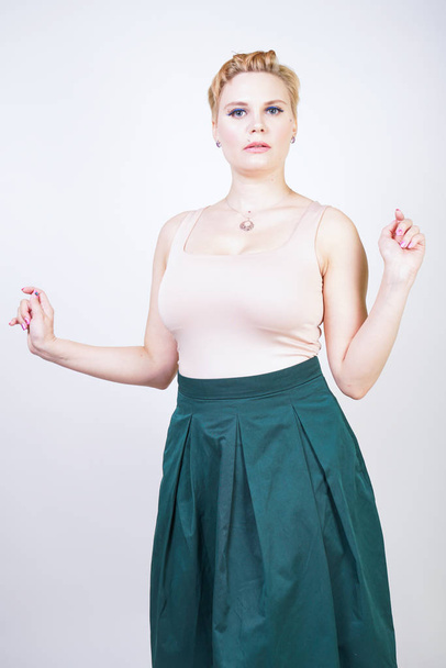 Pin up curvy girl in green pleated midi skirt on white - Photo, Image