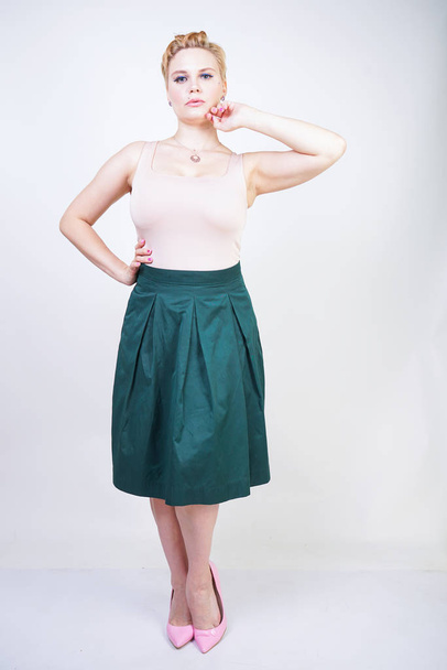 Pin up curvy girl in green pleated midi skirt on white - 写真・画像