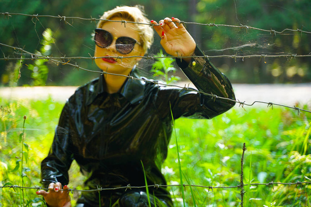 latex rubber fashion woman walking in the forest - Foto, imagen