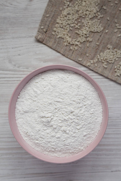 Farinha de arroz sem glúten em uma tigela rosa, vista superior. Deitado plano, overh
 - Foto, Imagem