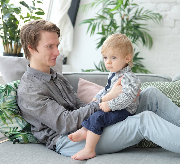 lifestyle, family and people concept - Happy young father with his one year old son playing at home - Foto, imagen