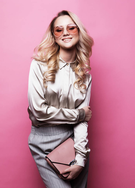 Young beautiful blond woman wearing blouse, pants and sunglasses - Fotó, kép
