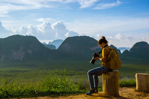 Jonge vrouw reist om foto 's te maken van de natuur op de berg. Reisavontuur. Landschap Prachtige Berg op zee bij Samet Nangshe Viewpoint. Phang Nga Bay, Reizen Thailand, zomervakantie. - Foto, afbeelding