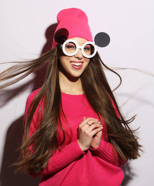 estilo de vida, la belleza y el concepto de la gente: joven linda chica sonriente con suéter rosa y gafas de sol divertidas
 - Foto, imagen