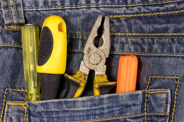 Pliers and screwdrivers in the jeans pocket - Photo, Image