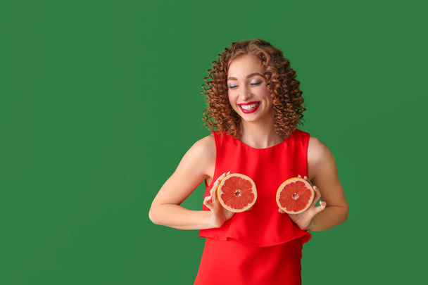 Happy young woman with tasty grapefruit on color background - Foto, Imagen