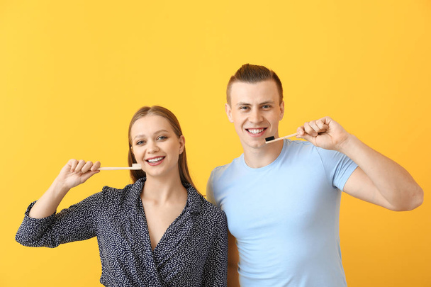Happy couple with toothbrushes on color background - Zdjęcie, obraz