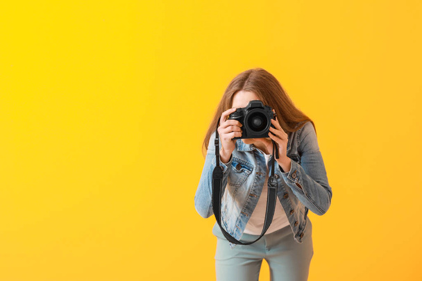 Young female photographer on color background - Photo, Image
