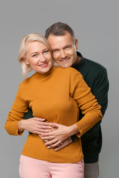 Šťastný pár středního věku na šedém pozadí - Fotografie, Obrázek