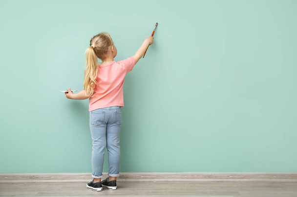 Little girl painting on color wall - Zdjęcie, obraz