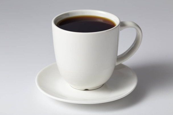 明るい灰色の背景にコーヒーのカップ - 写真・画像