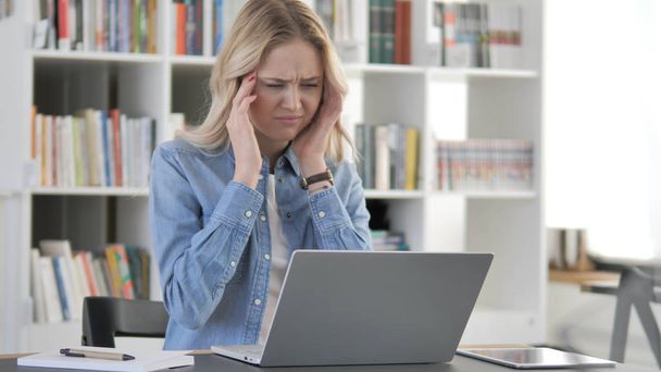 Dolor de cabeza, mujer rubia joven con dolor de cabeza Trabajando en el ordenador portátil
 - Foto, Imagen