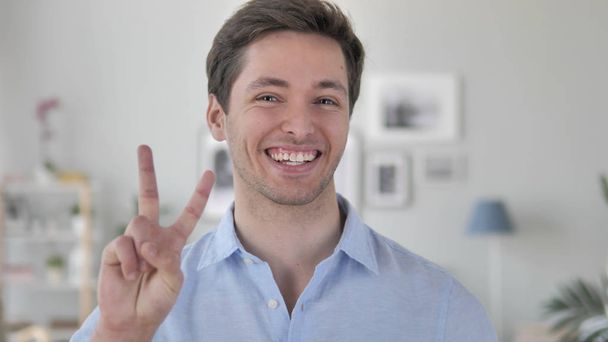 Victory Sign by Positive Handsome Young Man - Фото, зображення