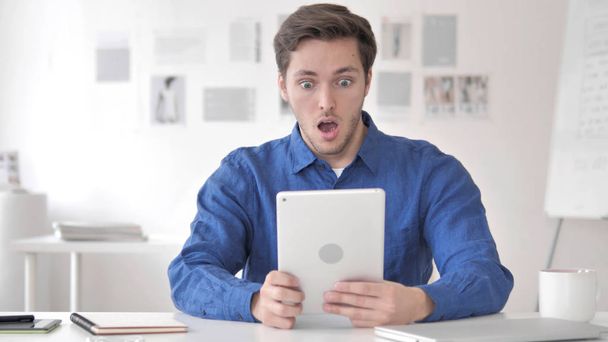 Hombre adulto casual en shock mientras usa la tableta
 - Foto, imagen