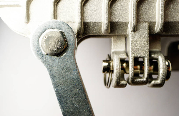 Sechskantschraube wird mit einem Schraubenschlüssel an der Metalleinrichtung in einer silberfarbenen Verbindung entdreht - Foto, Bild