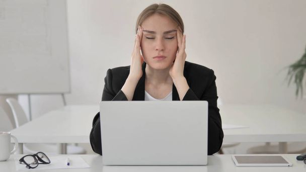 Stressato giovane imprenditrice con mal di testa che lavora sul computer portatile
 - Foto, immagini
