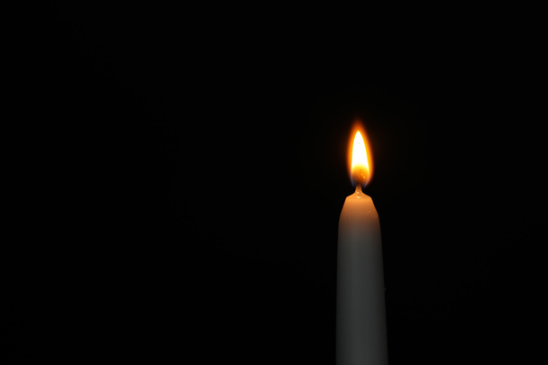 Зажигание свечи на тёмном фоне, место для текста. Символ скорби
 - Фото, изображение