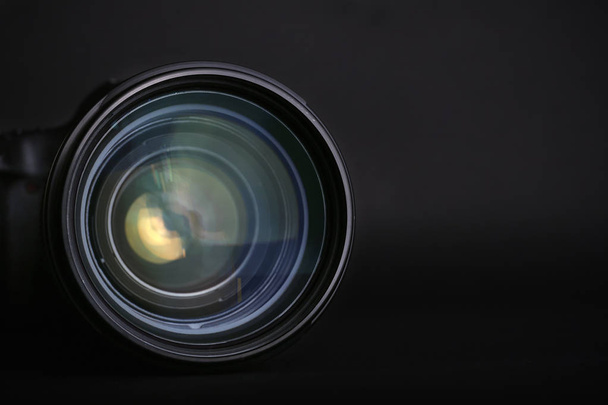 Modern camera lens on black background, closeup. Space for text - Foto, afbeelding