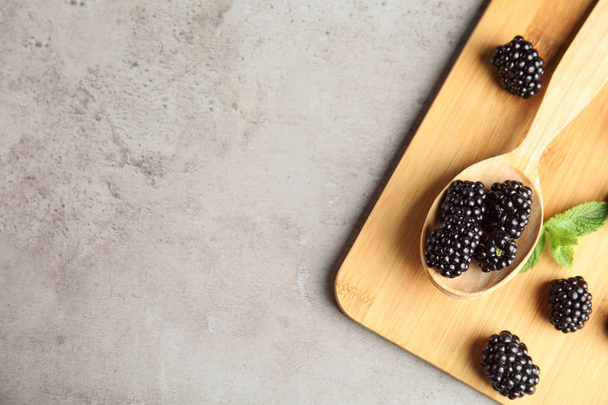 Flat lay composition of ripe blackberries on grey table, space for text - Foto, Bild