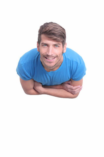 top view. smiling guy in a blue t-shirt looking at the camera - Фото, изображение