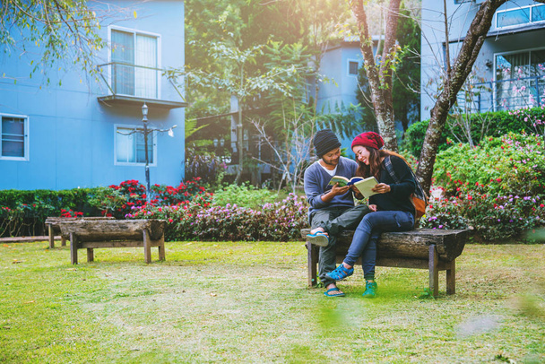 Das asiatische Paar lächelte und freute sich über das gelesene Buch. inmitten der wunderschönen Blumengärten, - Foto, Bild