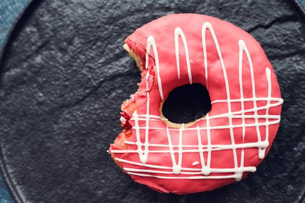 rosafarbener Donut auf dunklem Hintergrund - Foto, Bild